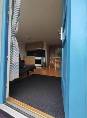 a room with a door open to a living room at Sonniges Studio mit Aussicht in Oberegg