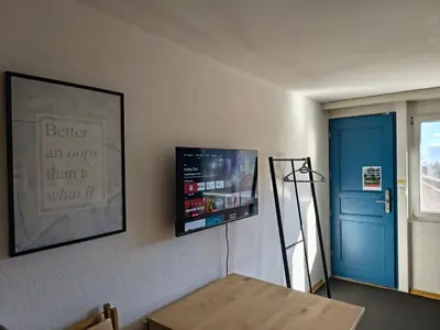 a room with a table and a blue door at Sonniges Studio mit Aussicht in Oberegg