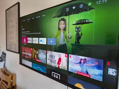 a flat screen tv with a picture of a girl with an umbrella at Sonniges Studio mit Aussicht in Oberegg