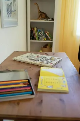 a wooden table with books and pencils on it at Rietgarten in Wildhaus