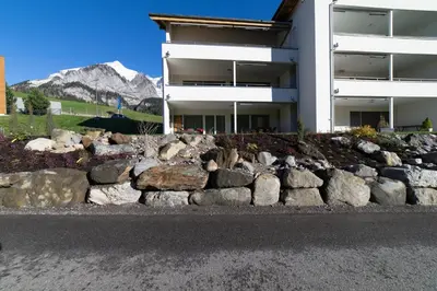 a rock retaining wall in front of a building at Rietgarten in Wildhaus