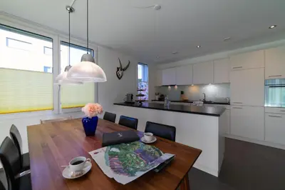 a kitchen and dining room with a wooden table at Rietgarten in Wildhaus