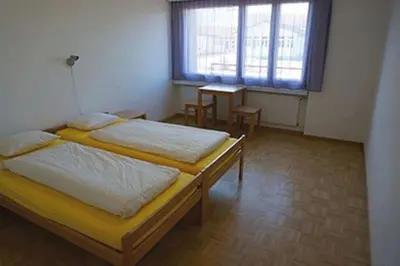 a bedroom with two beds and a window at Jugendherberge Romanshorn in Romanshorn