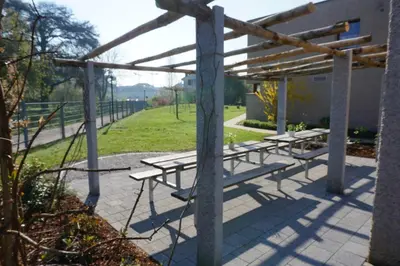 a group of picnic tables sitting under a pergola at Jugendherberge Romanshorn in Romanshorn
