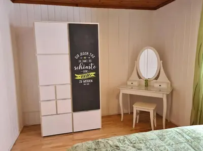 a bedroom with a bed and a mirror and a table at Naturoase Säntisblick-Auszeit am Wald und Bach in Kradolf