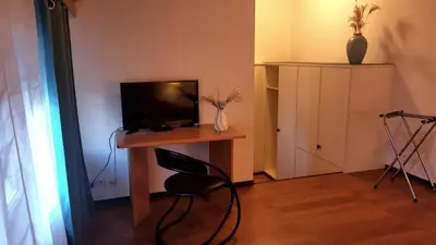 a room with a desk with a television and a chair at il fiore Hotel Steinach SG in Steinach