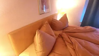 a bed with pillows sitting next to a wall at il fiore Hotel Steinach SG in Steinach