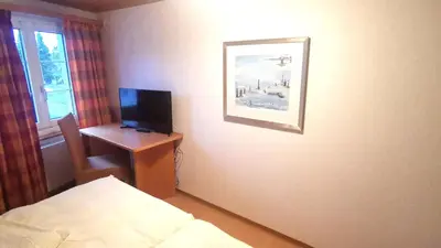 a room with a bed and a desk with a television at il fiore Hotel Steinach SG in Steinach