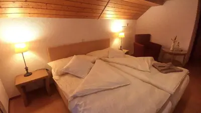 a bedroom with a large white bed with two lamps at il fiore Hotel Steinach SG in Steinach