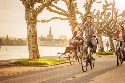 a group of people riding bikes down a street at Hotel SiX in Kreuzlingen