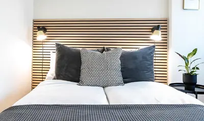 a bedroom with a bed with black and white pillows at INN JOY Apartments - Sankt Gallen Center in St. Gallen