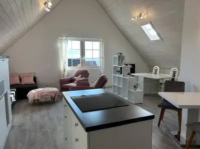 a kitchen and living room with a couch and a table at Dachwhg an schöner Aussichtslage in Berneck