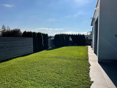 a yard with green grass next to a building at Deluxe Zimmer in Privatwohnung an zentraler Lage in Teufen