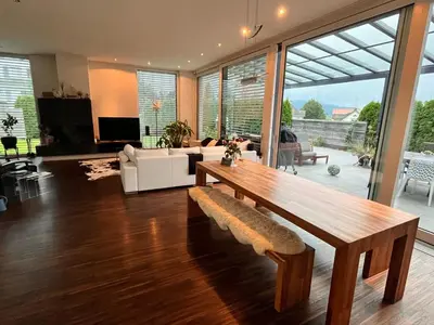 a living room with a wooden table and a couch at Deluxe Zimmer in Privatwohnung an zentraler Lage in Teufen
