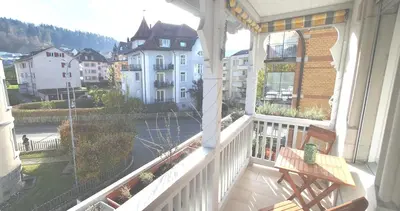 a balcony with a bench and a view of a city at 2-4 Zimmer Apartments Stilvoll im Gertrud Schlössli - zentral ruhig in St. Gallen