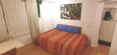 a bedroom with a bed with a colorful blanket at Stilvoll Gertrud Schlössli 1 Zi Studio in St. Gallen