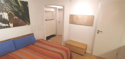 a living room with a bed and a door with a painting at Stilvoll Gertrud Schlössli 1 Zi Studio in St. Gallen