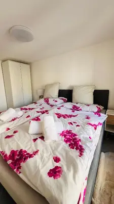 a large bed with pink flowers on it at Cresta Apartment in St. Gallen