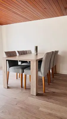 a wooden table with two chairs and a wooden ceiling at Cresta Apartment in St. Gallen
