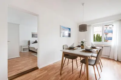 a dining room with a table and chairs and a bedroom at SOHO 13 !Gratis Parken, Free Parking! in Kreuzlingen