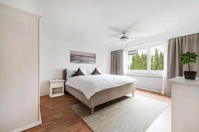 a white bedroom with a bed and a window at SOHO 13 !Gratis Parken, Free Parking! in Kreuzlingen