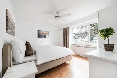 a white bedroom with a bed and a window at SOHO 13 !Gratis Parken, Free Parking! in Kreuzlingen