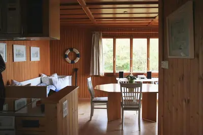 a kitchen and dining room with a table and chairs at Haus am Seeufer mit Veranda in natürlicher Umgebung in Güttingen
