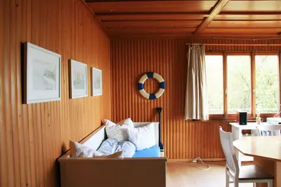 a living room with a couch and a table at Haus am Seeufer mit Veranda in natürlicher Umgebung in Güttingen