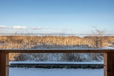 a wooden fence with snow on it in a field at Haus am Seeufer mit Veranda in natürlicher Umgebung in Güttingen