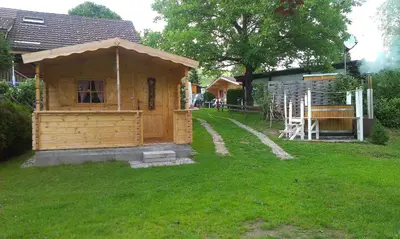 a small wooden house in the grass in a yard at Pilger-Hüttli - Blockhaus in Schönengrund