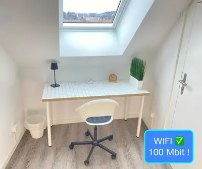 a desk and a chair in a room with a window at Ruhige, neue Dachwohnung an Altstadt, nähe Messe in St. Gallen