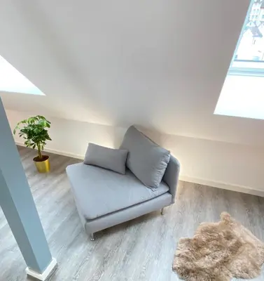 a living room with a couch in a attic at Ruhige, neue Dachwohnung an Altstadt, nähe Messe in St. Gallen