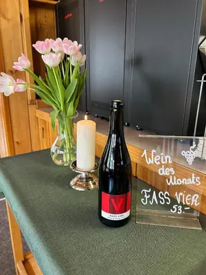 a bottle of wine and a candle and flowers on a table at Gasthof Ochsen in Nesslau