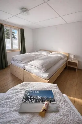 a bedroom with two beds and a book on a table at Gasthof Ochsen in Nesslau