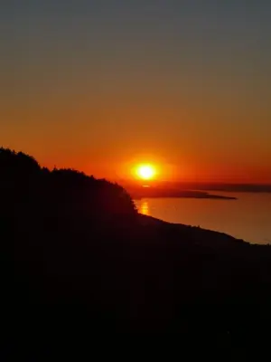 a sunset over the water with the sun in the sky at Gästehaus Eisenhut in Walzenhausen
