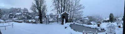 a yard covered in snow with trees and houses at Ferienwohnung mit Aussicht in Gais