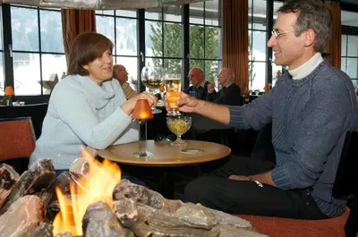 a man and woman sitting at a table with glasses of wine at Hotel-Restaurant Sternen in Nesslau