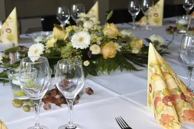 a table with wine glasses and a vase of flowers at Hotel-Restaurant Sternen in Nesslau