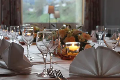 a table with wine glasses and a candle on it at Hotel-Restaurant Sternen in Nesslau