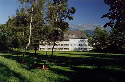 a large white building in the middle of a field at Hotel-Restaurant Sternen in Nesslau