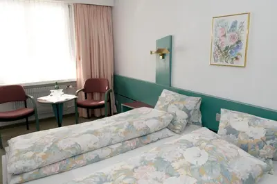 a hotel room with a bed and a table at Hotel-Restaurant Sternen in Nesslau