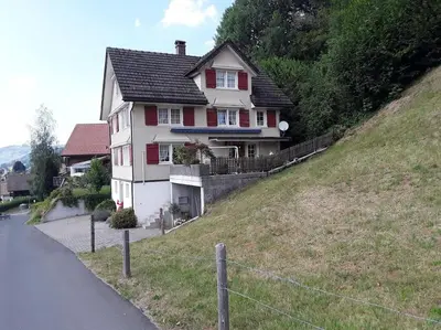 a house on the side of a hill at Zwinglis Ferienwohnung Rosi in Nesslau