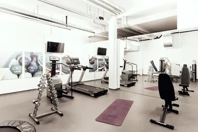 a gym with treadmills and machines in a room at Newstar Hotel (Free Parking) in St. Gallen