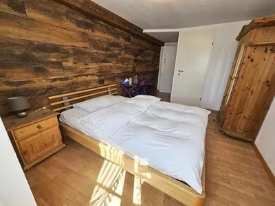 a bedroom with a bed and a wooden wall at Hotel Taverne zur Linde in Bischofszell