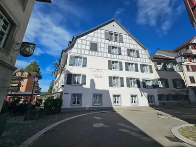 a white building on a street at Hotel Taverne zur Linde in Bischofszell
