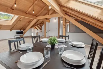 a dining room with a table with white plates and chairs at FENUS Grabs Gemütliche Ferienwohnung SGT06 in Grabs