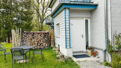 a patio with a table and chairs next to a door at Seesicht und charmante Wohnung bei Hanni und Ueli in Bottighofen