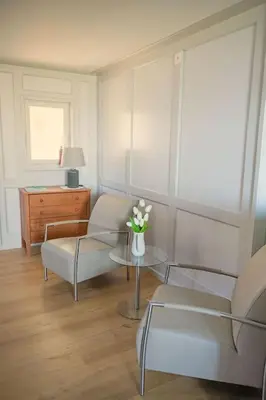 a living room with two chairs and a table with flowers at Seesicht und charmante Wohnung bei Hanni und Ueli in Bottighofen