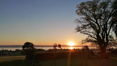 a heart hanging from a tree with the sunset in the background at Seesicht und charmante Wohnung bei Hanni und Ueli in Bottighofen