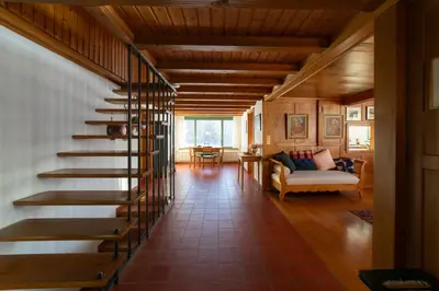 a wooden staircase in a living room with a couch at Chammern in Nesslau